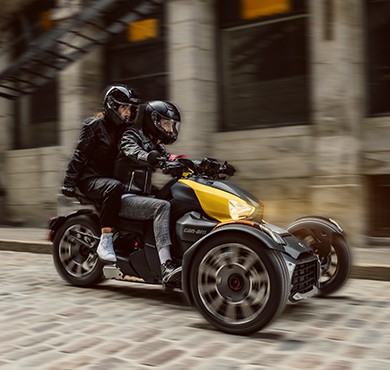 Couple riding a Can-Am Ryker vehicle with shock yellow panels Couple riding a Can-Am Ryker vehicle with shock yellow panels